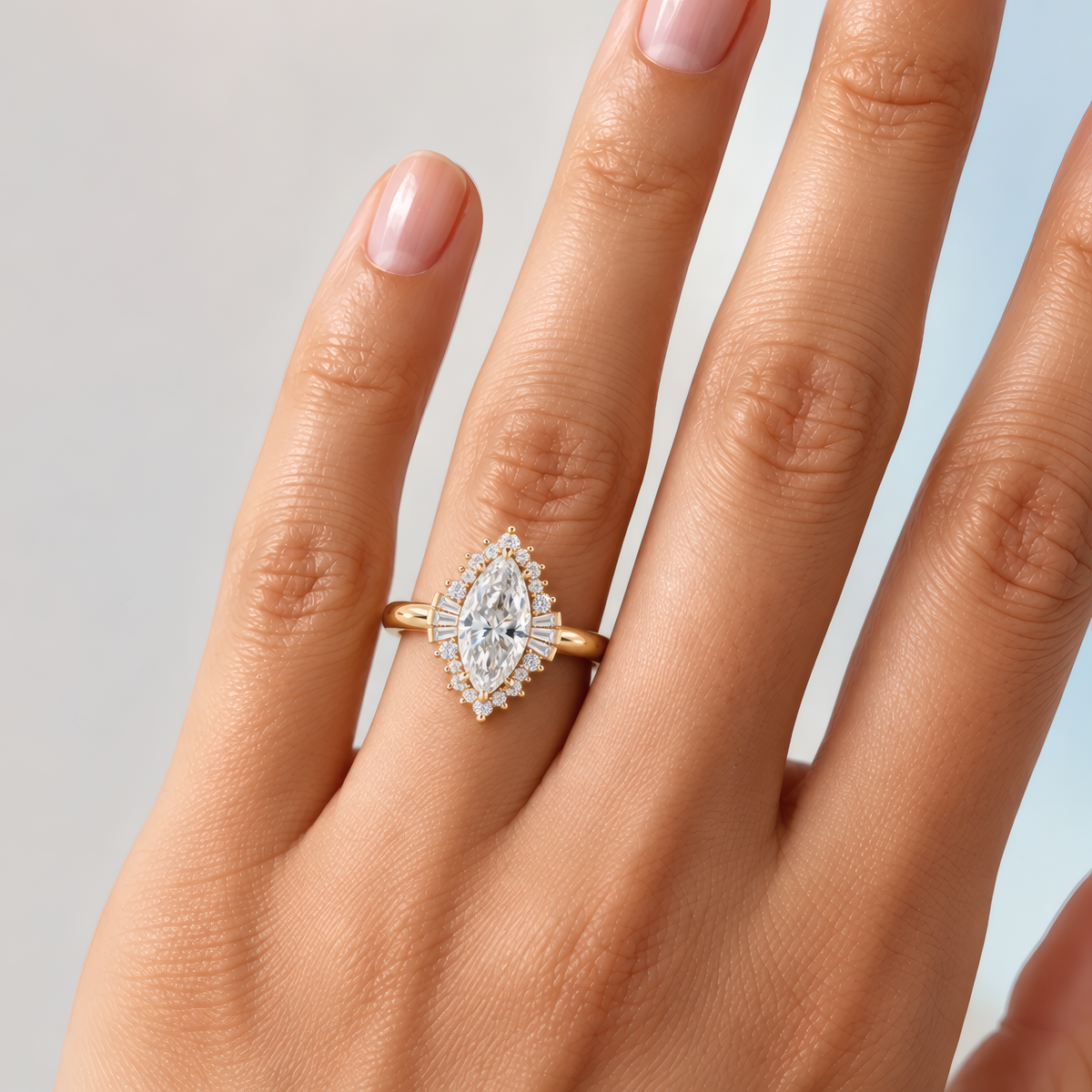 Delicate woman's left hand wearing a unique marquise halo engagement ring on the ring finger.