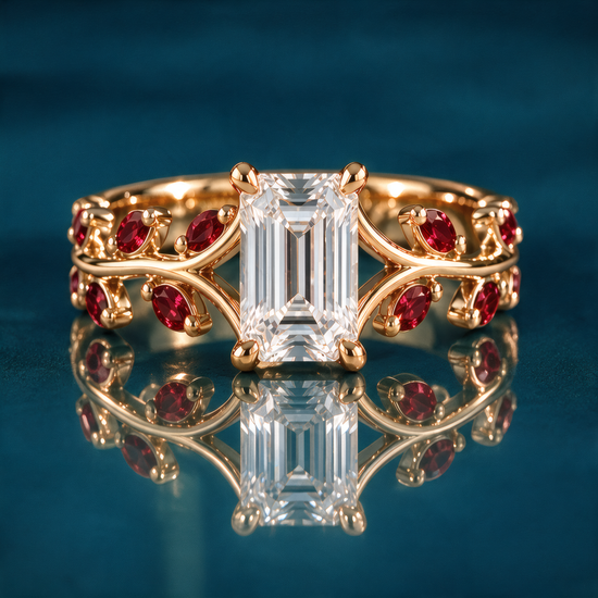 Rosella engagement ring in yellow gold with an emerald-cut diamond in four claw prongs on an open double vine band set with ruby marquise leaves and round ruby accents