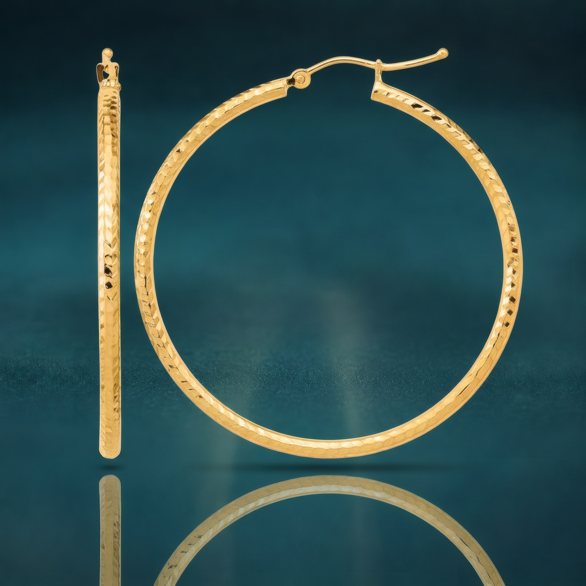 40mm 10k yellow gold classic hoop earrings with a diamond-cut finish, on a reflective teal surface.