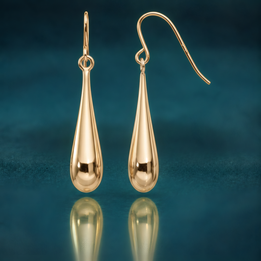Polished 14k yellow gold teardrop dangle earrings on French hooks, on a reflective teal surface.