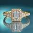 Unique gold halo engagement ring with an emerald-shaped center and 2 baguette diamonds on each side of the halo, moving down the shank. The rest of the shank is set with round diamonds via prong in channel.