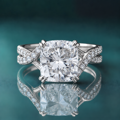 Unique white gold split-shank twist shank engagement ring with a cushion-shaped center diamond and double claw prongs. Small diamonds cover the twisting split shank.