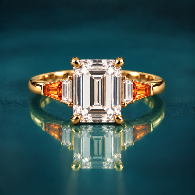 Gold engagement ring with emerald-cut diamond set in four classic prongs, framed by tapered amber baguettes and crisp diamond side stones that step down gracefully to a polished band.