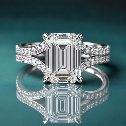White gold emerald-shaped engagement ring with a split shank and accent diamonds.