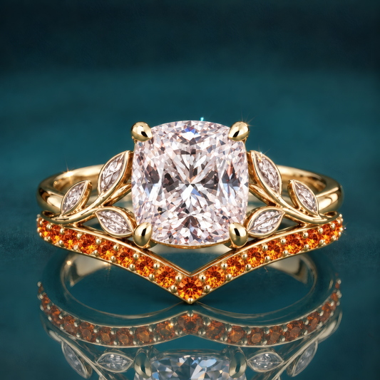 Ember is a gold engagement ring with a cushion-shaped center diamond embraced by a vivid orange curved wedding band and sculpted leaf accents, all the warmth of fall in a single statement piece.