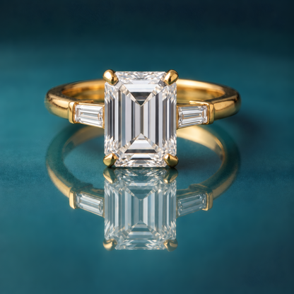 Gold three-stone engagement ring with an emerald-cut center diamond and baguettes on the sides.