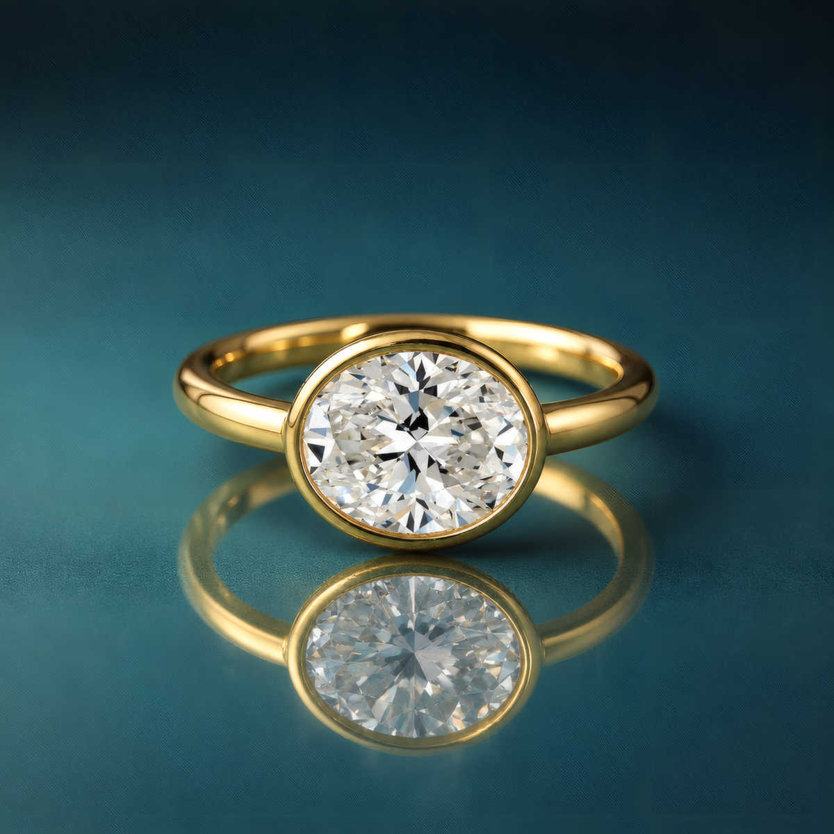 Gold solitaire bezel oval engagement ring