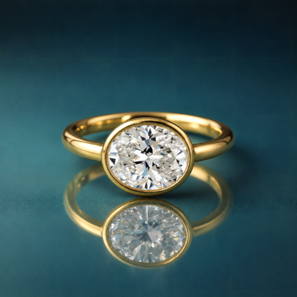 Gold solitaire bezel oval engagement ring
