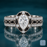 Melo engagement ring in white gold with a pear-shaped diamond in a halo of black marquise stones and round diamonds, set on a wide milgrain pavé band with a center row of black marquise accents