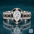 Melo engagement ring in white gold with a pear-shaped diamond in a halo of black marquise stones and round diamonds, set on a wide milgrain pavé band with a center row of black marquise accents
