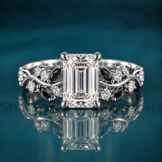 Noctis pairs white gold with an emerald-cut diamond with a winding vine band set with deep black marquise accents and sparkling round diamonds, a striking contrast of light and shadow.