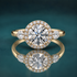 Gold halo three-stone engagement ring with a round center diamond and 2 pear-shaped side diamonds.
