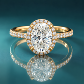 A gold oval halo engagement ring with a pavé-set band
