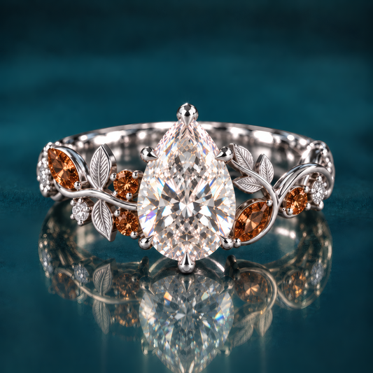 Sorrel sets a graceful pear-shaped diamond within a sculpted band of white gold leaves and warm cognac diamonds that curl around the finger like an autumn branch.