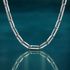 Bold 18" 4.4mm sterling silver diamond-cut paperclip chain on a reflective teal surface.