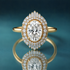 Unique gold double halo engagement ring with an oval-shaped diamond in the center. Milgrain surrounds the center diamond, then a row of small tapering round diamonds, then another layer of round and baguette-shaped diamonds on the top and bottom of the inner halo. The shank is narrow and shiny.